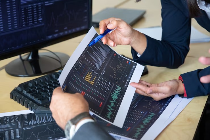 imgi_4_brokers-discussing-trading-strategy-holding-papers-with-financial-data-pointing-pen-charts-cropped-shot-broker-job-stock-market-exchange-concep